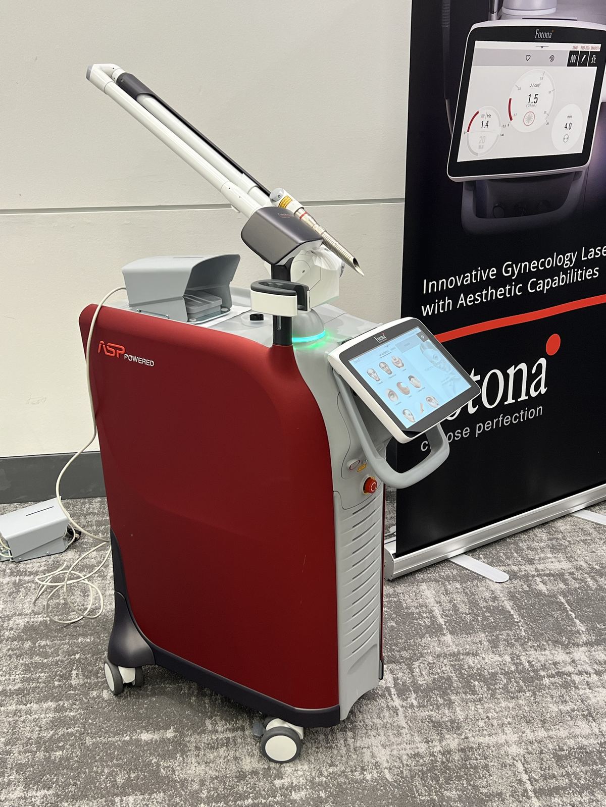 The Fotona TimeWalker laser, a red and silver cart-mounted platform with a touchscreen and articulated arm